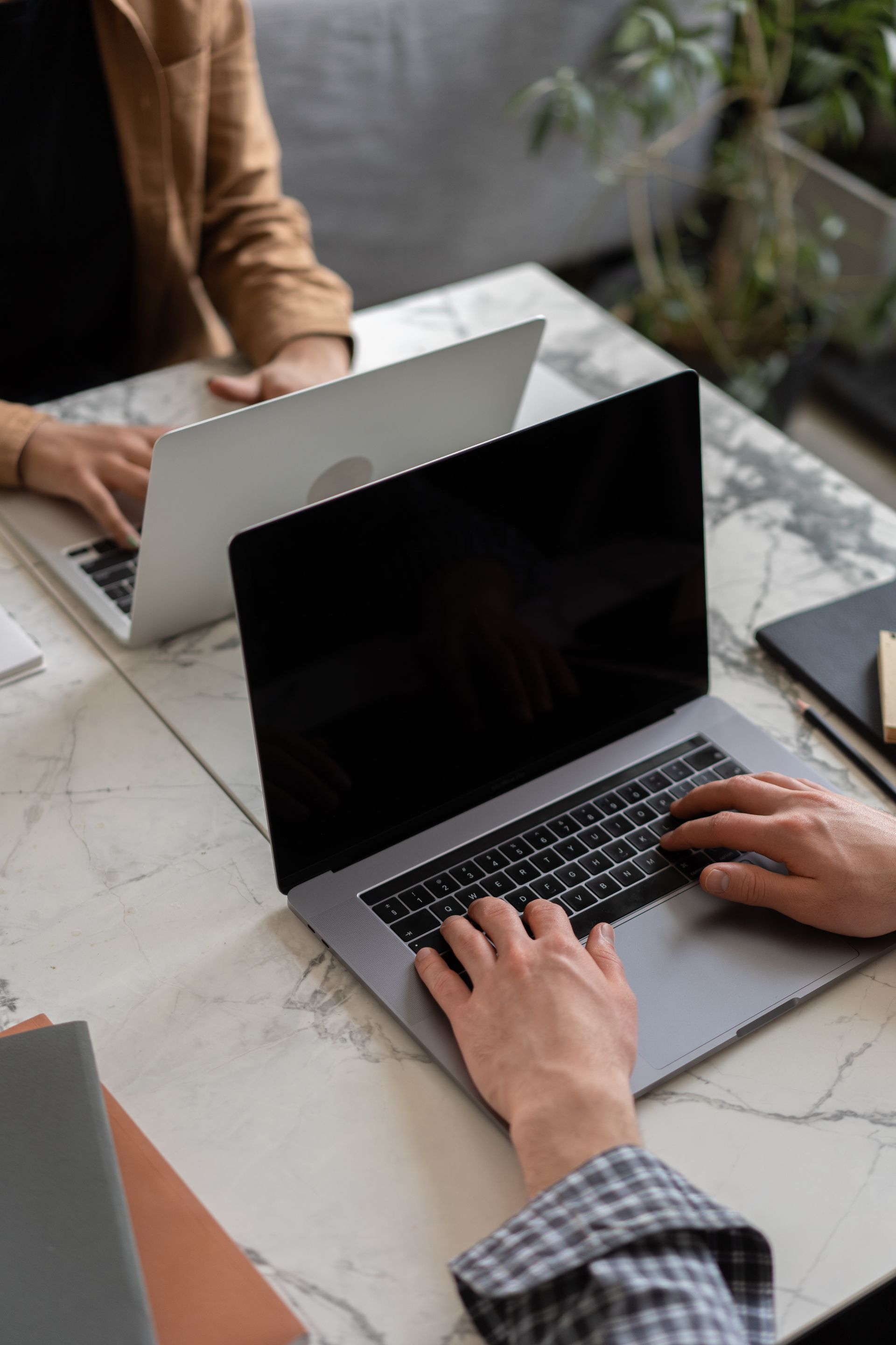 Hands typing on a laptop at a desk