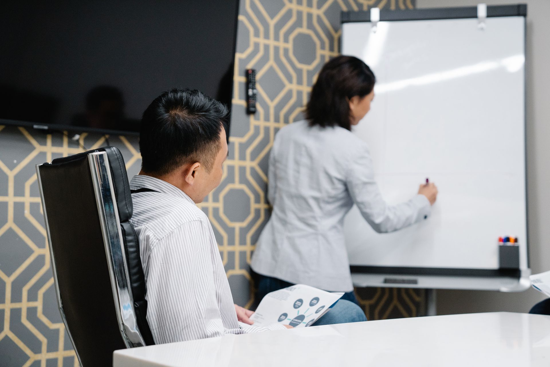 Two people planning a project at a whiteboard